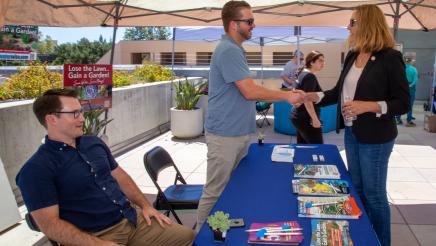 Asm. Irwin greeting staffers of booth providing info on drought-tolerant plants