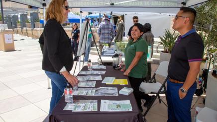Asm. Irwin speaking with staffers of the County of Ventura Human Services Agency booth