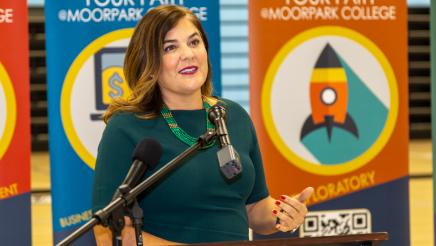 Campaign for College Opportunities President Michele Siqueiros at podium, speaking