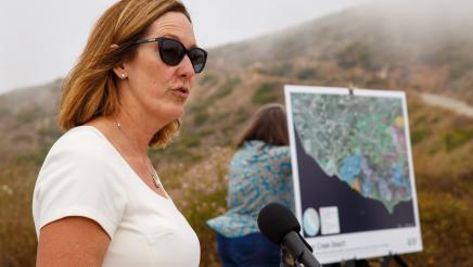 Asm. Irwin speaking to press with map of Deer Creek Beach in background
