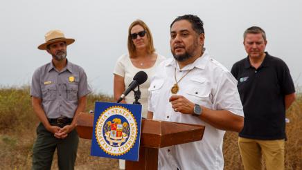 Rudy Ortega of the Santa Monica Mountains Conservancy at podium, speaking