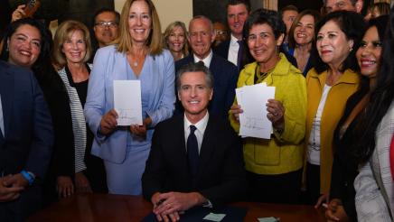 Assemblymember Irwin and Senator Eggman hold signed copies of their bills