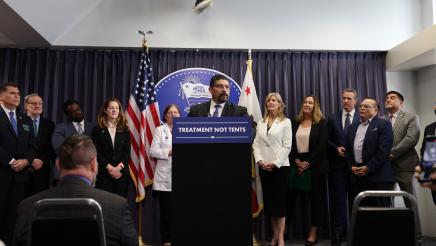 Attendees, including Governor Newsom and Assemblymember Irwin listen as James Espinoza CEO of The Veteran Mentor Project speaks on historic mental health reform