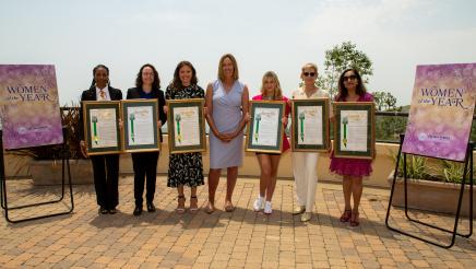 Group photo of Asm. Irwin and all honorees holding up framed awards