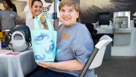 Smiling constituent holding up gift bag