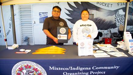 Mixteco/Indigena table staffers displaying materials