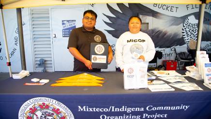 Mixteco/Indigena table staffers displaying materials