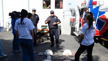 Paramedics providing CPR instruction to three attendees