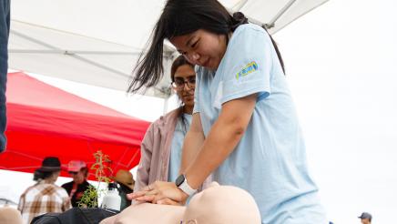 Student performing CPR on manikin