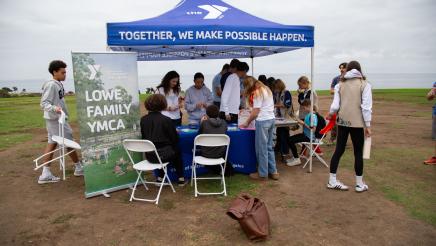 Staffers assisting attendees at Lowe Family YMCA table