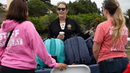 Asm. Irwin speaking with staffers with backpacks on table
