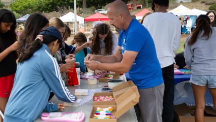 Staffer assisting attendees with crafts at table