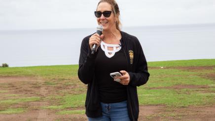 Asm. Irwin holding microphone while speaking